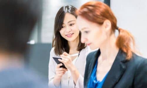 interprete che prende appunti ascoltando una riunione tra importanti manager