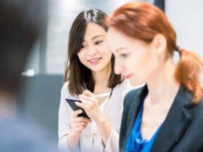 interprete che prende appunti ascoltando una riunione tra importanti manager